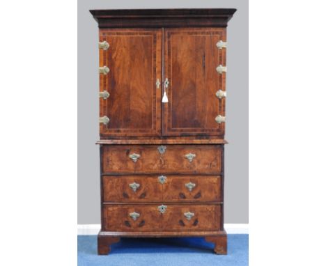 An early 18th century and later walnut feather banded cabinet on chest, the sectional veneered moulded cornice over two cross