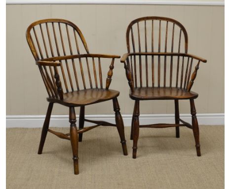 Two 19th Century Windsor Armchairs in ash and elm with stick backs, solid seats on turned legs united by H stretchers