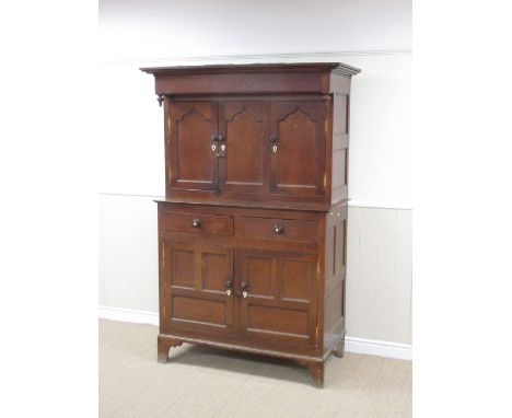 A 19th Century Welsh oak Court Cupboard with three recessed cupid's bow panelled doors fronted by turned finials, the base fi