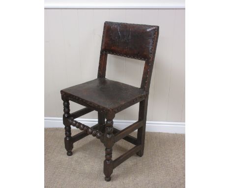 A 17th Century oak Side Chair with leather upholstered back and seat on bobbin turned and square front legs and stretchers