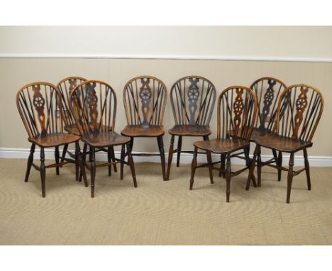 A set of eight Windsor Dining Chairs with stick and wheelbacks, solid seats on turned supports united by H stretchers