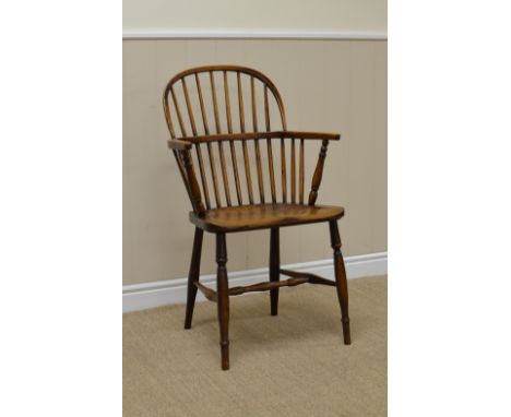 A 19th Century Windsor Elbow Chair in ash and elm with stick back, solid seat on turned legs united by H stretchers