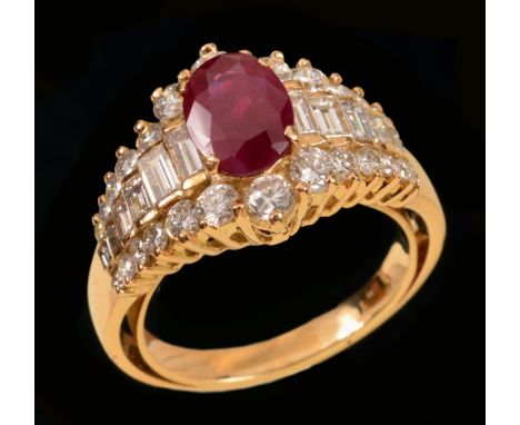 A Ruby and Diamond Ring claw-set oval-cut ruby between rows of channel-set graduated baguettes and two rows of brilliant-cut 