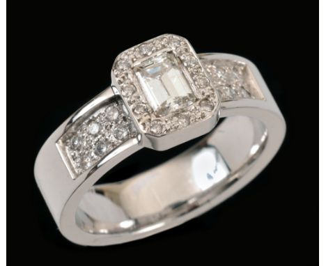 A Diamond Ring set step-cut stone, 0.57cts, within a frame of pavé-set brilliant-cut stones and double rows of brilliant-cut 