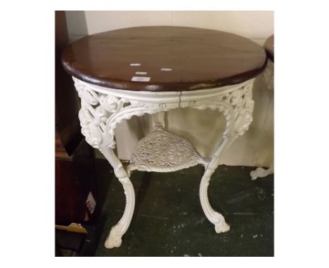 Victorian style white painted cast iron pub table with pierced and mask castings to the three curved legs, which join a pierc