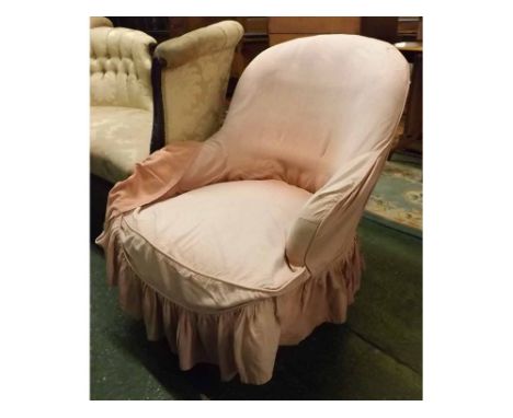 Late Victorian button back armchair with pink loose covers, front turned legs and casters