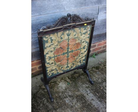 A 19th century carved mahogany firescreen with crewel work panel, on splay supports, 23" wide (for restoration) and an Edward