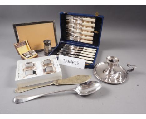 A silver plated chamber stick, a plated pepper grinder, a plated photo frame, loose plated cutlery, napkin rings and other it