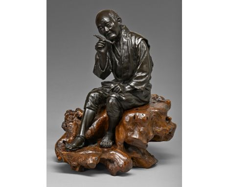 A Japanese bronze sculpture of a man, seated with contemplative expression holding his tobacco pipe in his right hand, even r