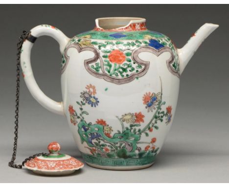 A Chinese famille verte teapot and cover, Kangxi period, enamelled with flowers sprouting from hollow rocks beneath broad man