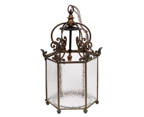 An hexagonal brass hall lantern, early 20th c, in George III style, with six pairs of looped C-scrolls and pierced anthemia t