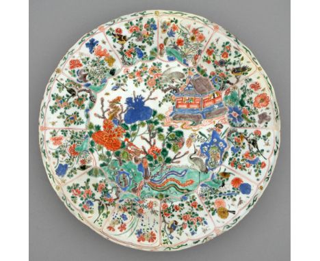 A Chinese famille verte dish, Kangxi period, enamelled with temple, phoenix, cranes and flowering plants in lightly moulded l