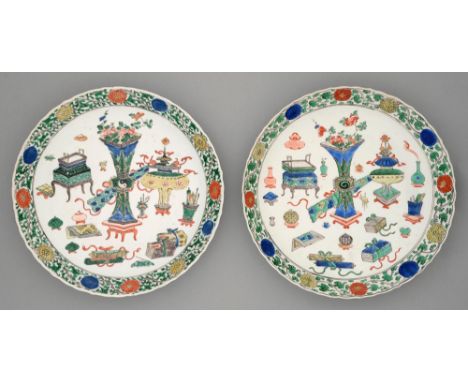 Two Chinese wucai dishes, Kangxi period, painted with sacrificial vessels and auspicious emblems bordered by linked flowerhea