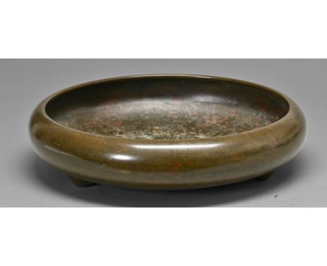 A Japanese bronze flower arrangement&nbsp; bowl, Meiji period, of shallow rounded form with inverted rim and three vestigial 