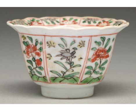 A Chinese famille verte tea bowl, Kangxi period, painted with flower panels to the exterior and lobed, everted border, 53mm h