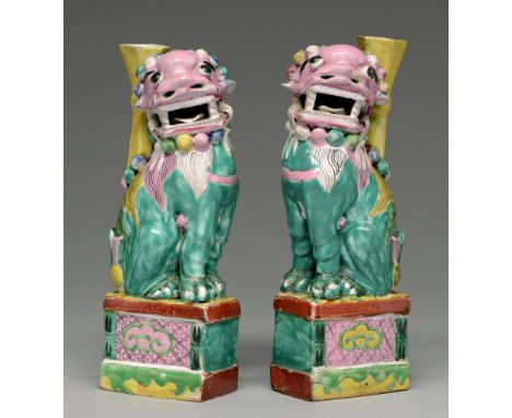 Two Chinese polychrome dog of Fo censers, 19th c, the vivid green lion dog with pink head and green mane, a yellow vase on it