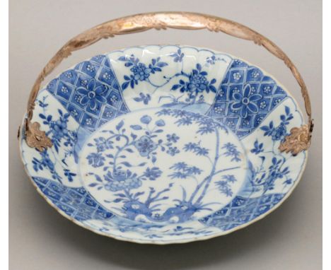 A Chinese blue and white dish, Kangxi period, painted with peony and bamboo sprouting from hollow rocks in panelled border, a