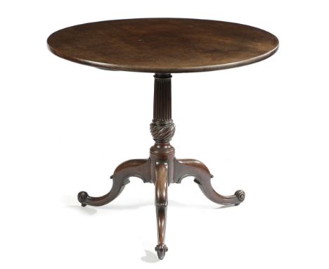 AN EARLY GEORGE III MAHOGANY TRIPOD TABLE C.1760 the circular tilt-top above a fluted stem and a spiral ribbed bowl, on scrol