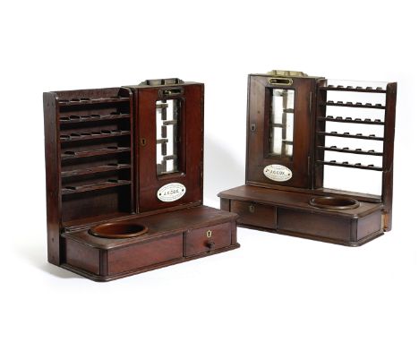 A PAIR OF VICTORIAN MAHOGANY STAMP DISPENSERS BY J. COX with brass mounts and with a base drawer, applied with an enamel plaq