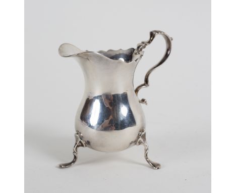 A silver helmet-shaped cream jug, JBC &amp; Son Ltd., Birmingham 1974, on three scroll feet, 10cm high, approximately 130gm