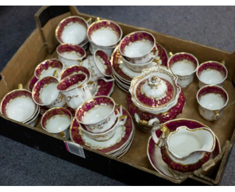 A Staffordshire part tea service decorated in gilt on a crimson ground, comprising sugar basin and cover, slop bowl, jug, ten