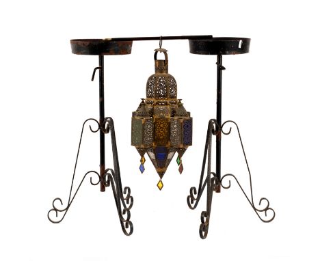 A pierced brass Turkish hanging lantern with coloured glass panels, 61cm high and two wrought iron jardinière stands 