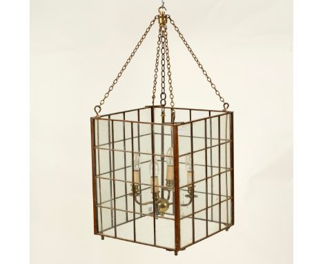 A brass framed glazed hall lantern of cube form suspended from four chains, the central four-branch light fitted for electric