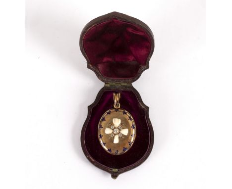 A Victorian oval locket decorated a cross in diamonds and childrens teeth, to a blue enamel border, in a fitted case/Provenan