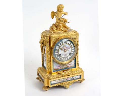 A gilt metal mounted eight-day mantel clock with porcelain mounts, the segmented dial with Roman numerals, 31cm high