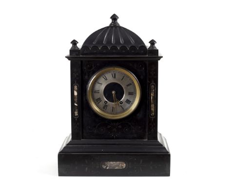 A black slate mantel clock the silvered dial with Roman numerals, the sides inset panels of marble and the dome top decorated
