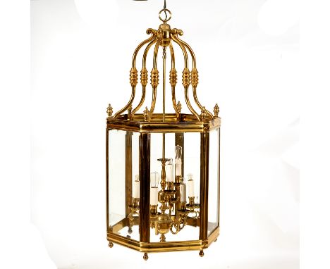 A large gilt brass hall lantern, of hexagonal shape, the scrolling top above bevelled glass panel sides, fitted for electrici