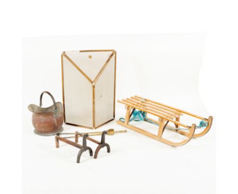 A helmet-shaped copper coal scuttle, a pair of andirons, a pair of fire tongs, a spark guard and a toboggan