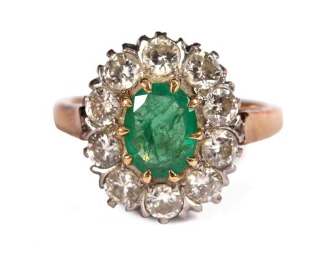 An emerald and diamond cluster ring, the oval emerald to a surround of ten diamonds, claw set to an 18ct yellow gold shank, s