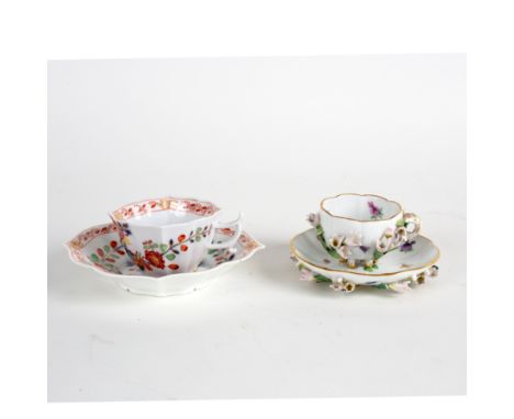 A Meissen cup and saucer of ogee outline painted flowers in the Kakiemon style and another Meissen cup and saucer decorated e