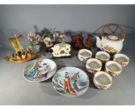 A hand painted Chinese tea set, carved wooden figures, plates, a vintage Japanese celluloid model of a Dragon boat with seven