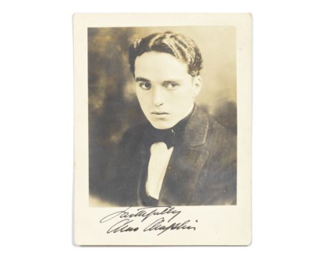 Charlie Chaplin: A Signed Postcard Photograph,circa 1910,vintage sepia portrait photo of Chaplin, signed in black fountain pe