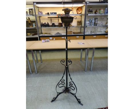 An Arts and Crafts style wrought iron, copper and brass telescopic standard oil lamp, in the manner of WAS Benson,  CONDITION