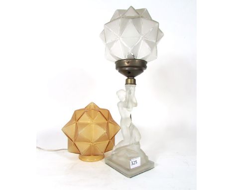 An Art Deco style moulded and frosted glass table lamp modelled as a naked woman on a rocky base supporting a star shaped sha