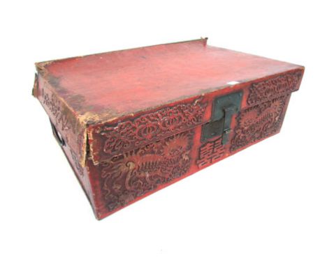 A Chinese tooled leather travelling trunk, the front decorated with dragons either side of the lock plate and a large charact