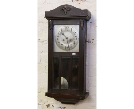 A 1930s oak cased eight day wall clock with silvered dial, Arabic numeral markers and striking on a gong.