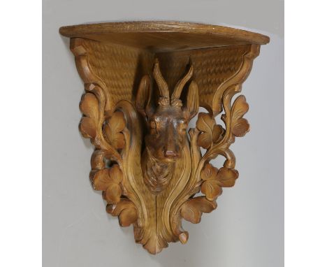 A Black Forest carved wall hanging corner shelf depicting a stag.