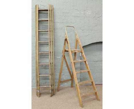 A wooden three section ladder and set of wooden step ladders.