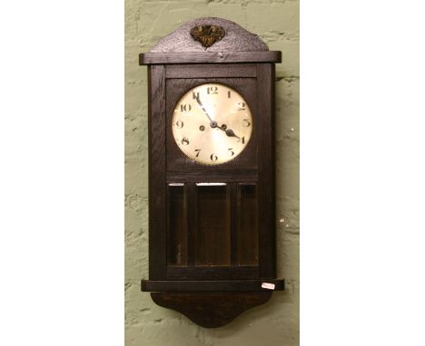 A 1930s oak cased eight day wall clock with silvered dial and Arabic numeral markers.