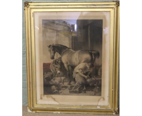 A Victorian gilt framed monochrome print of a Blacksmith shoeing a horse.