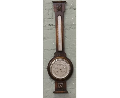 An oak cased banjo barometer with silvered dial.