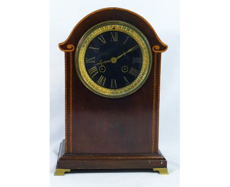 An Edwardian dome topped mahogany cased line inlaid mantel clock, the black dial with gilt Roman numerals and ornate gilt met