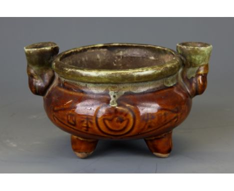 An interesting Chinese glazed pottery oil lamp, W. 15cm, H. 9cm.