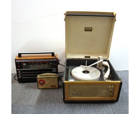 A vintage portable record player and two transistor radios.