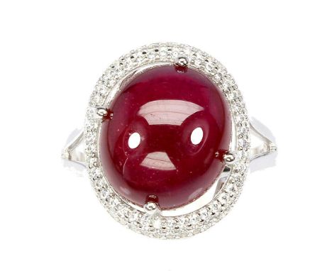 A 925 silver ring set with a large cabochon cut ruby surrounded by white stones, (P).