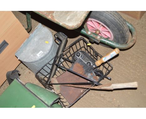 A basket and contents of various hand tools, bike seat, and a galvanised water tank